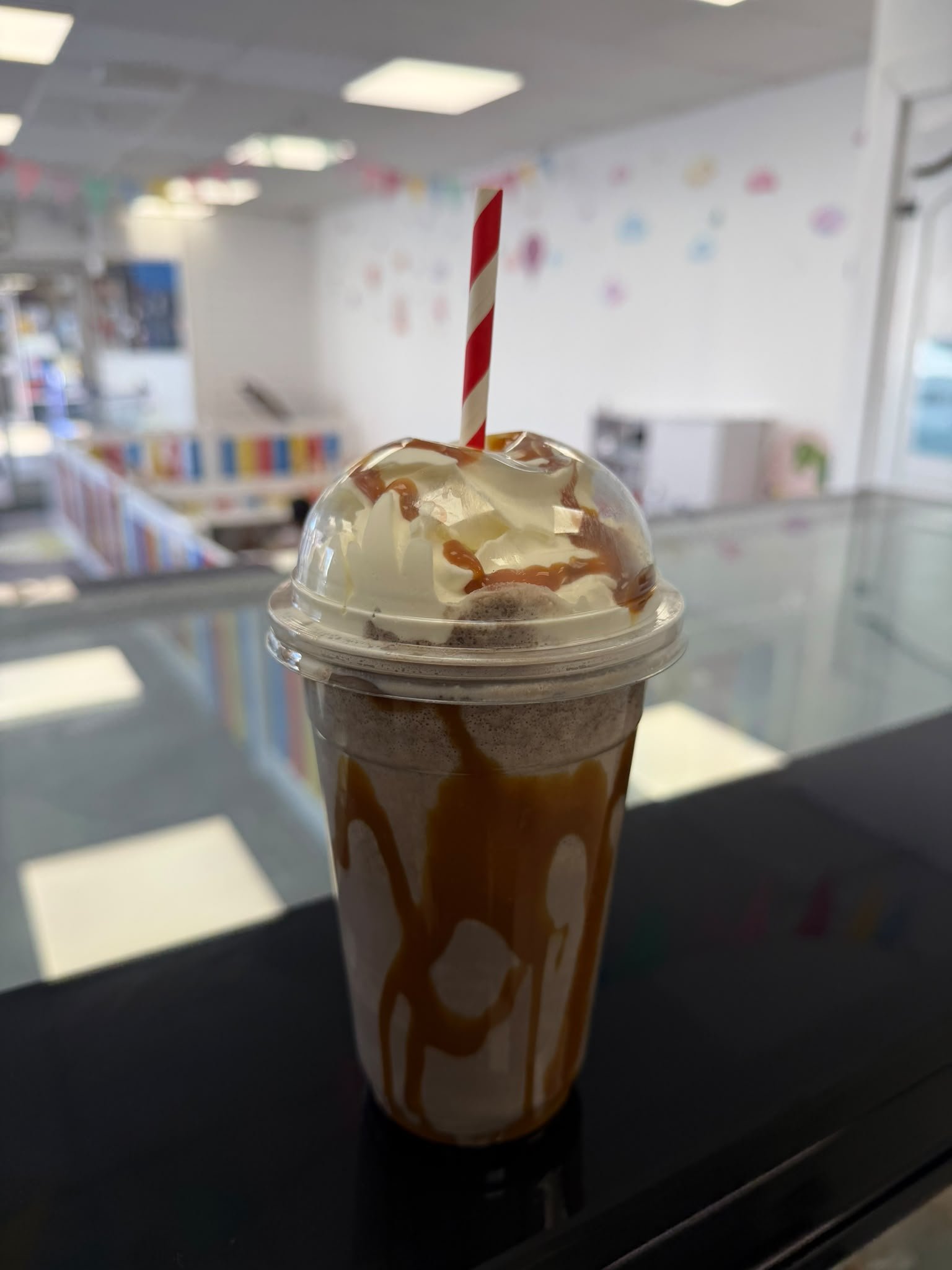 Caramel milkshake in front of the colourful play area